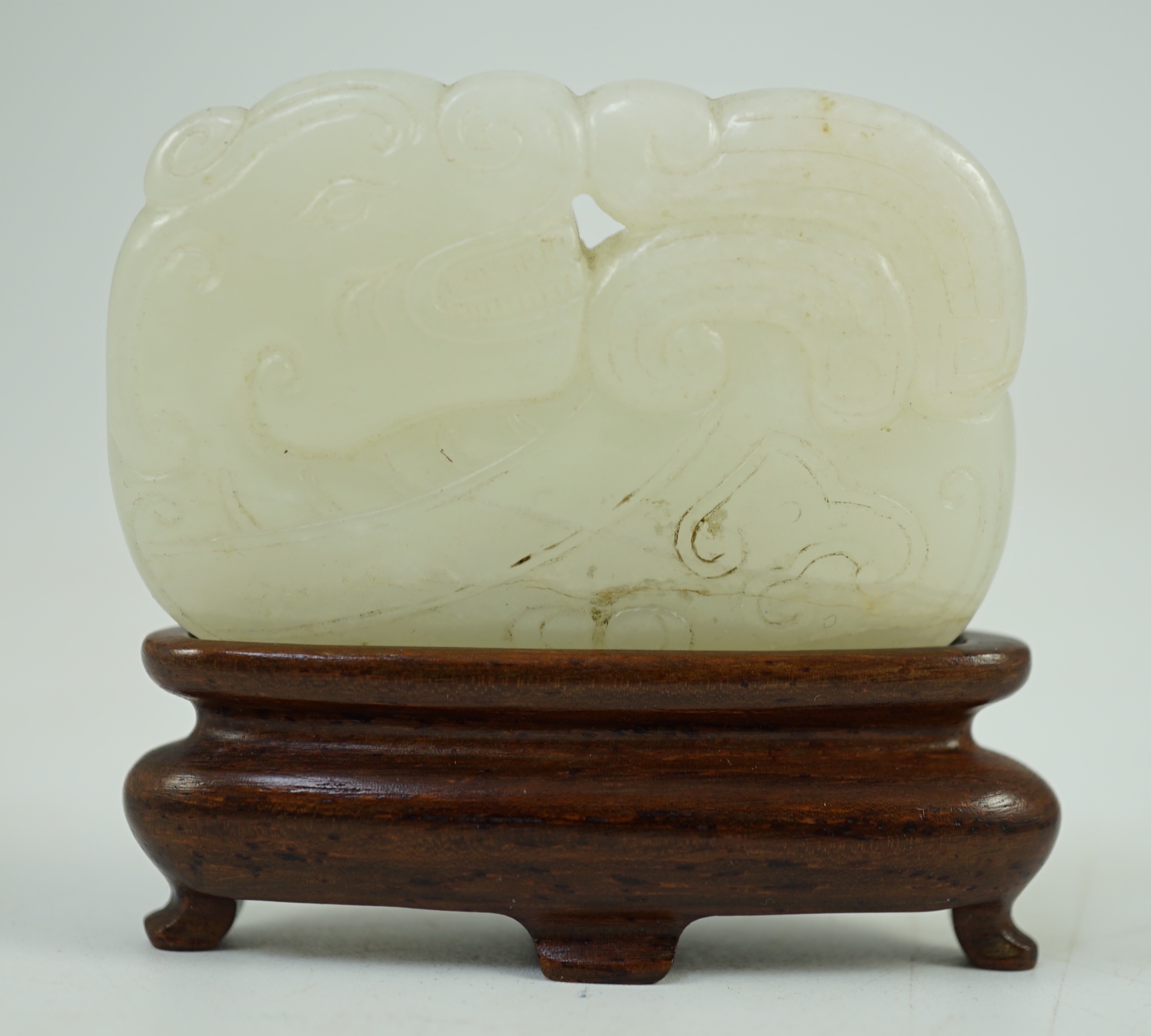 A Chinese white jade ‘tiger and dragon’ plaque, 18th/19th century 5.1 cm wide, wood stand